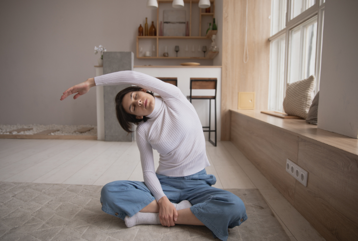Woman stretching in bedroom