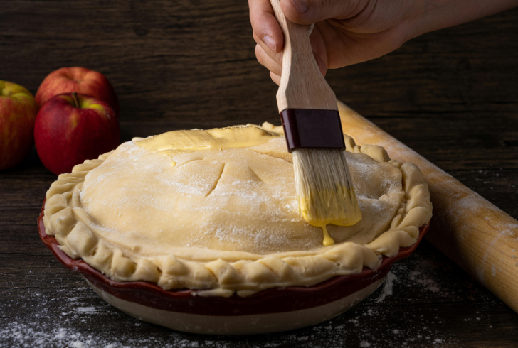 Brushing egg wash on pie crust